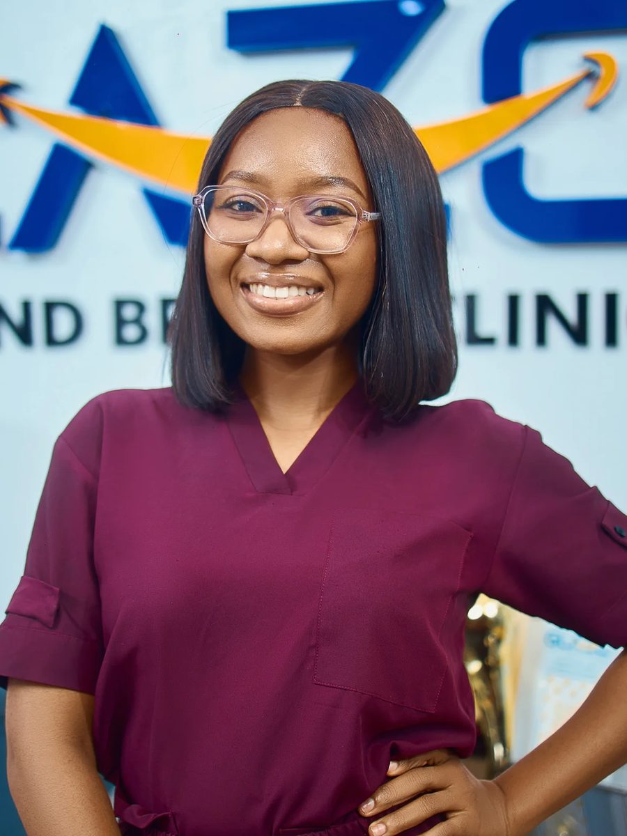 Gift, a member of the Glaze clinical team, smiling in front of the GLAZE wall